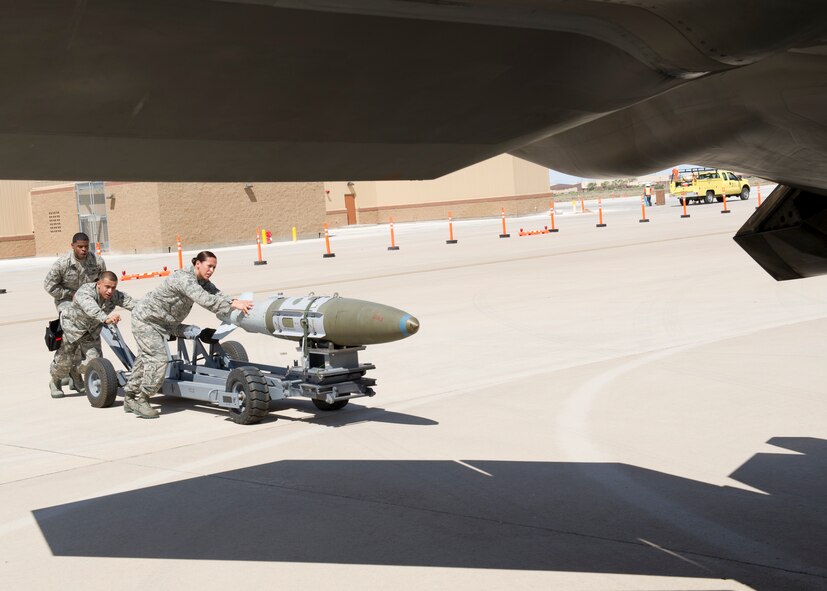 Airman 1st Class Nathan White, Senior Airman Vincent Miller, and Staff Sgt. Irma Hinton, 49th Aircraft Maintenance Squadron F-22 Raptor weapons load crew members, transport an inert GBU-32 Joint Direct Attack Munitions bomb to load into an F-22 during the second quarter load crew competition at Holloman Air Force Base, N.M., July 19. The F-22 load crew competed against MQ-9 Reaper and German Air Force load crews. For the competition, points are awarded during the weapons loading, tool kit inspection, and uniform inspection. (U.S. Air Force photo by Senior Airman Kasey Close/Released)