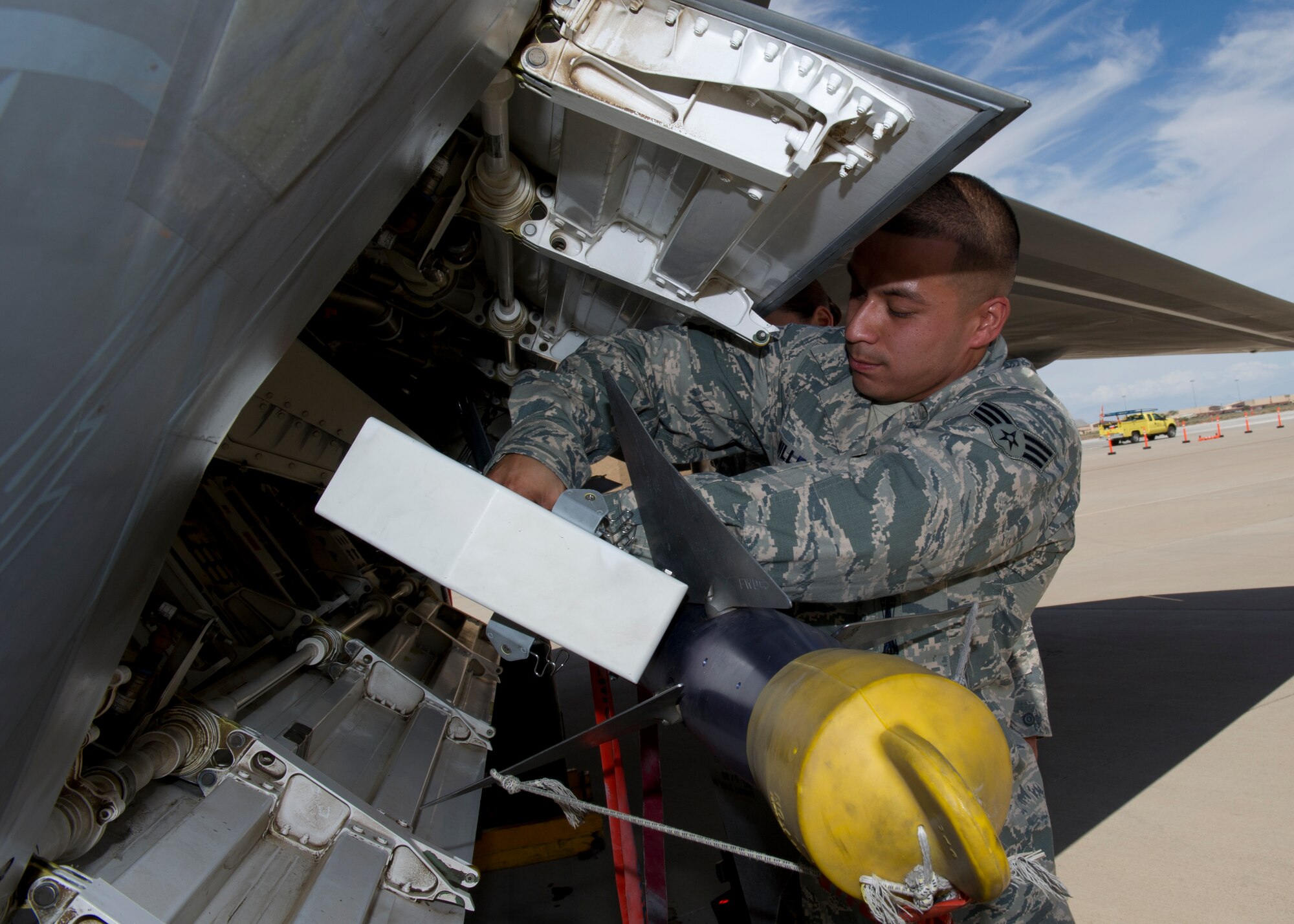 Senior Airman Vincent Miller, 49th Aircraft Maintenance Squadron F-22 Raptor weapons load crew member, secures an inert AIM-9 Sidewinder missile to an F-22 during the second quarter load crew competition at Holloman Air Force Base, N.M., July 19. The F-22 load crew competed against MQ-9 Reaper and German Air Force load crews. For the competition, points are awarded during the weapons loading, tool kit inspection, and uniform inspection. (U.S. Air Force photo by Senior Airman Kasey Close/Released)