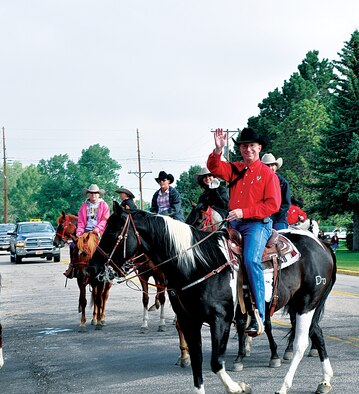 Col. Scott Fox, 20th Air Force vice commander and the 2013 Cheyenne Frontier Days military committee chairman, waves to the crowd as he makes his turn into Frontier Park, CFD grounds, Cheyenne, Wyo., July 14, 2013, during the conclusion of this year’s cattle drive. (U.S. Air Force photo by Airman 1st Class Brandon Valle)