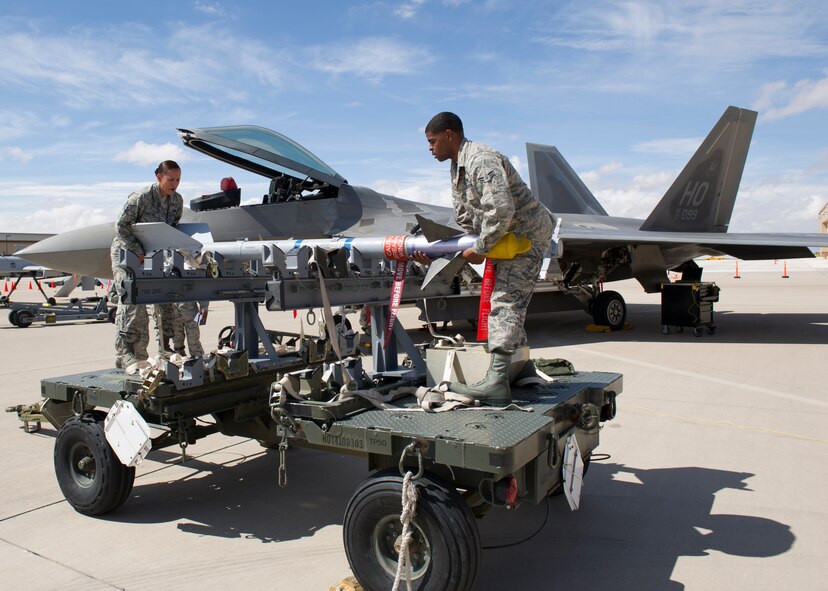 Staff Sgt. Irma Hinton and Airman 1st Class Nathan White, 49th Aircraft Maintenance Squadron F-22 Raptor weapons load crew members, position an inert AIM-9 Sidewinder missile in preparation for loading during the second quarter load crew competition at Holloman Air Force Base, N.M., July 19. The F-22 load crew competed against MQ-9 Reaper and German Air Force load crews. For the competition, points are awarded during the weapons loading, tool kit inspection, and uniform inspection. (U.S. Air Force photo by Senior Airman Kasey Close/Released)