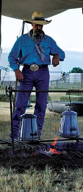 A cowboy watches the coffee as it percolates July 14, 2013, near the Iron Mountain and Yellowstone Roads, Cheyenne, Wyo., prior to the 2013 cattle drive. The cattle drive is one of the first events that start the annual Cheyenne Frontier Days “Daddy of ‘em All” rodeo. (U.S. Air Force photo by Senior Airman Mike Tryon)