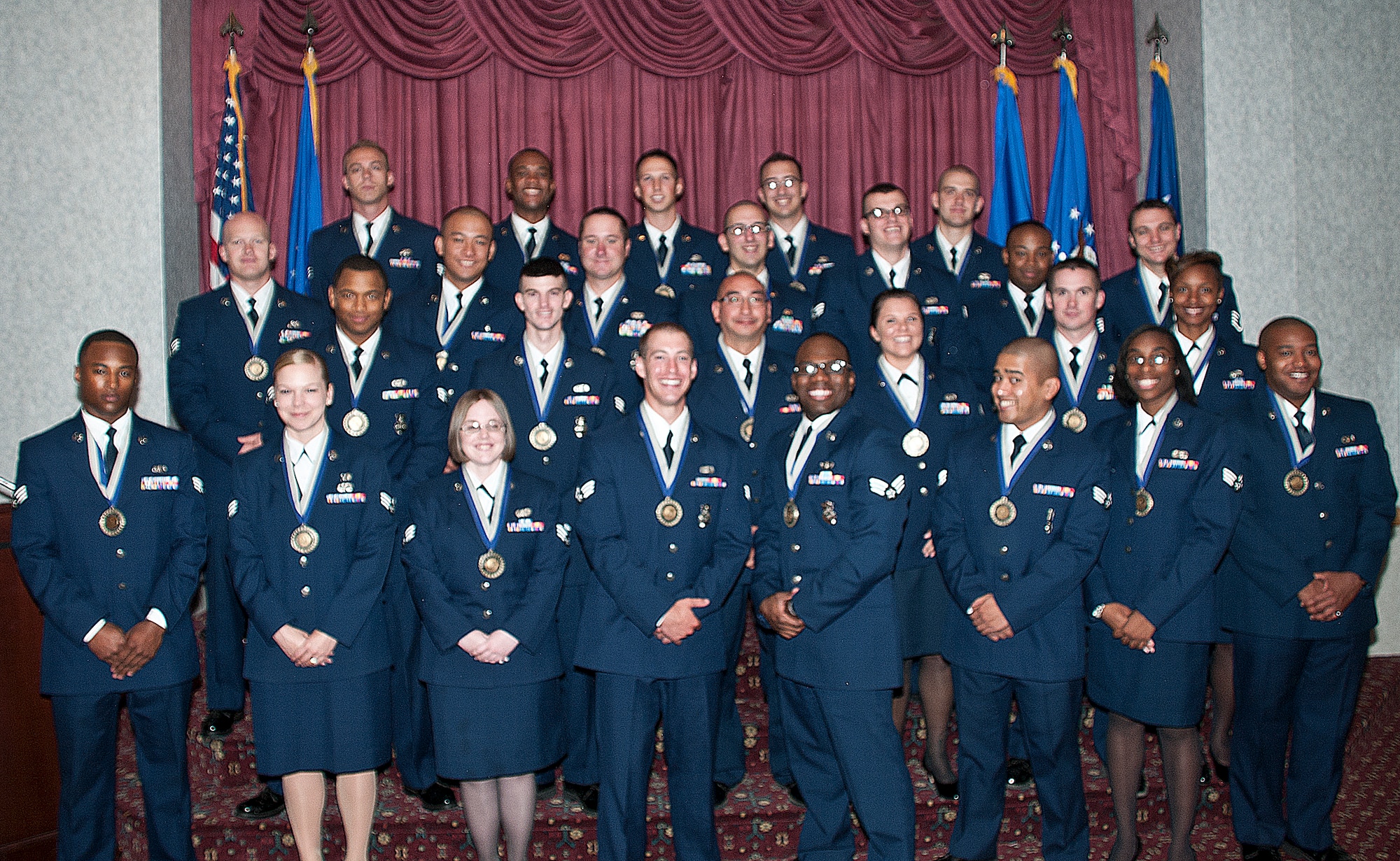 Airman Leadership School Class 13-E poses for a group photo on the stage in the Trail’s End Club, F.E. Warren Air Force Base, Wyo., at the beginning of their graduation ceremony July 10, 2013. ALS graduates have undergone professional military training in leadership, and the training is required for an Airman to become supervisors. (U.S. Air Force photo by Airman 1st Class Jason Wiese)