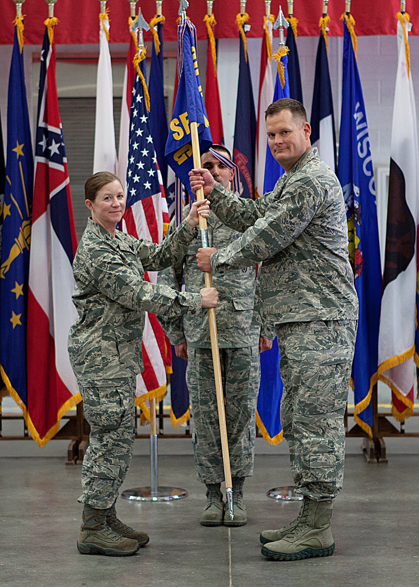 Col. Tracey Hayes, 90th Missile Wing commander, passes the 90th Security Forces Group guidon to Col. Craig Allton, 90th SFG commander, during a change-of-command ceremony July 15, 2013. (U.S. Air Force photo by Matt Bilden)