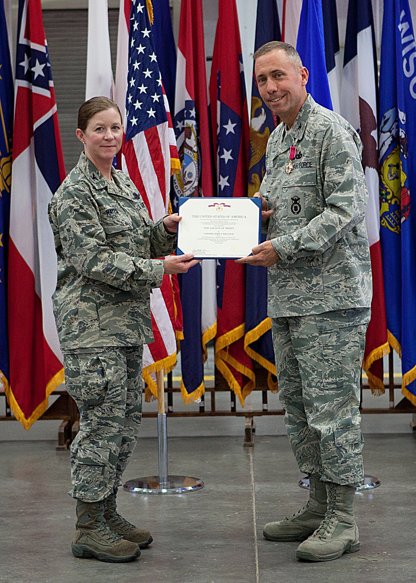 Col. Tracey Hayes, 90th Missile Wing commander, presents Col. Tom Wilcox, former 90th Security Forces Group commander, with a Legion-of-Merit medal during the 90th SFG change of command July 15, 2013. (U.S. Air Force photo by Matt Bilden)