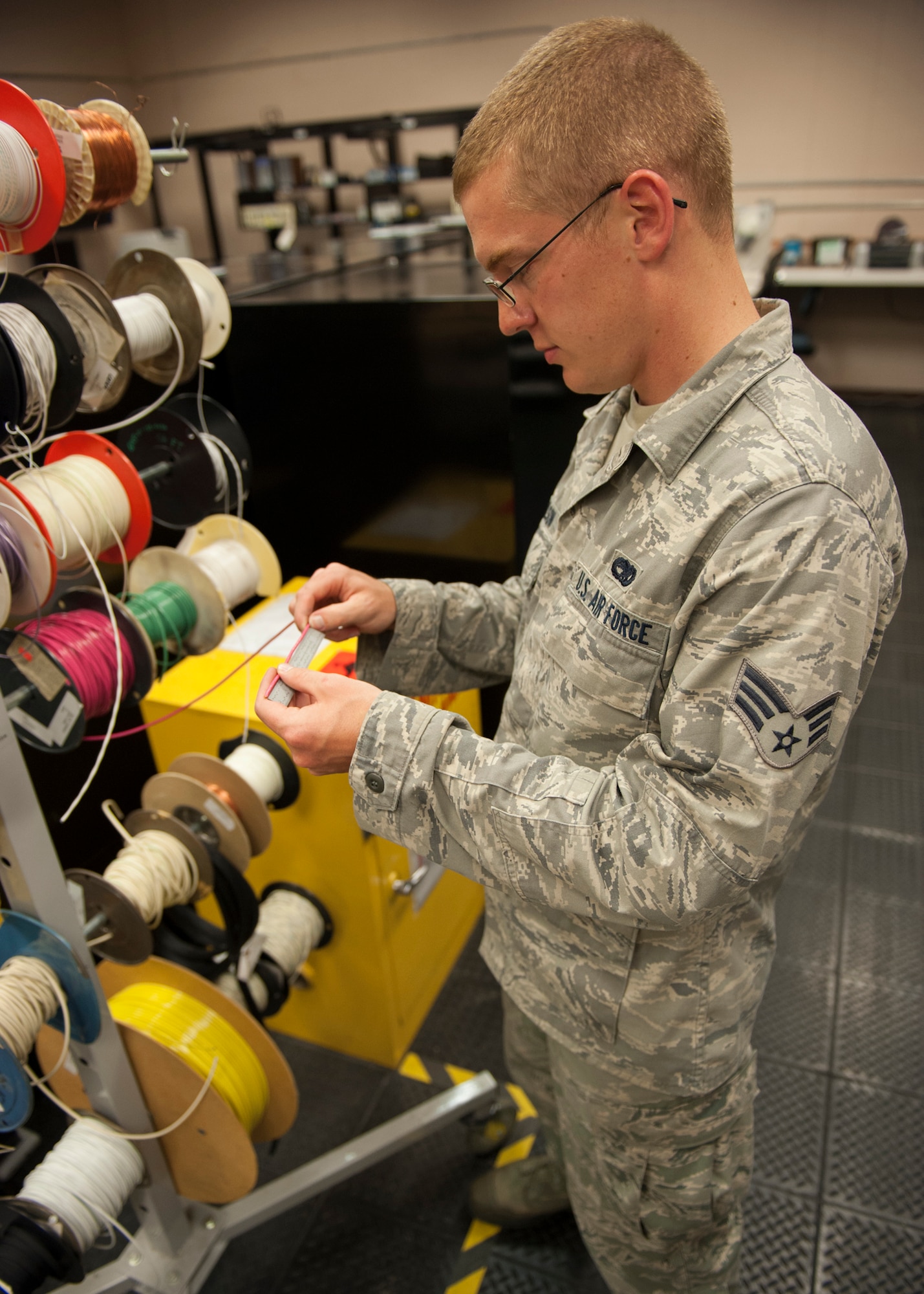 U.S. Air Force Senior Airman Chad Paulson, 23d Maintenance Group Air Force Repair Enhancement Program (AFREP) technician, pulls and measures cable off a spool from an operating stock at Moody Air Force Base, Ga., July 17, 2013. Paulson is one of five technicians at Moody who work within the AFREP, and give damaged equipment one last shot at being recovered to prevent costly replacements. (U.S. Air Force photo by Senior Airman Eileen Meier/Released)