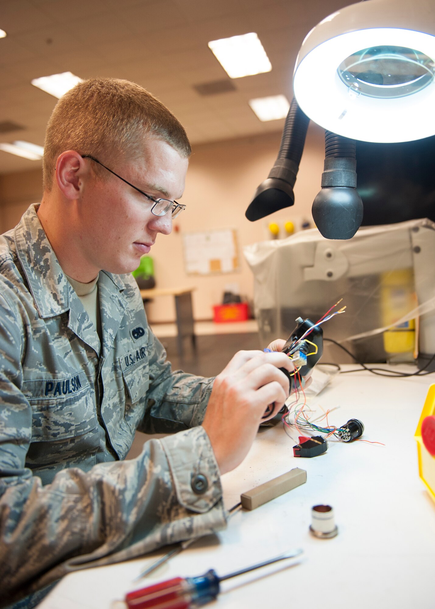 U.S. Air Force Senior Airman Chad Paulson, 23d Maintenance Group Air Force Repair Enhancement Program (AFREP) technician, replaces wires from an A-10C Thunderbolt joystick at Moody Air Force Base, Ga., July 17, 2013. AFREP saved $2.2 million in equipment last year and $980 thousand this year. (U.S. Air Force photo by Senior Airman Eileen Meier/Released)