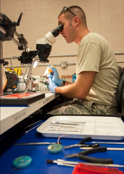 U.S. Air Force Tech. Sgt. Tim Haxton, 23d Maintenance Group Air Force Enhancement Program (AFREP) technician, applies a protective coating on an HH-60G Pave Hawk weapons system circuit card at Moody Air Force Base, Ga., July 17, 2013. Repairs by AFREP technicians have saved the Air Force close to $980 thousand this year so far. (U.S Air Force photo by Senior Airman Eileen Meier/Released)