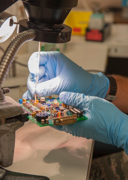 U.S. Air Force Tech. Sgt. Tim Haxton, 23d Maintenance Group Air Force Enhancement Program (AFREP) technician, cleans and repairs a circuit card for an HH-60G Pave Hawk electrical unit in the AFREP workshop at Moody Air Force Base, Ga., July 17, 2013. The AFREP program consists of skilled technicians from each Moody airframe who work together to improve cost-efficient repairing capabilities for the wing. (U.S. Air Force photo by Senior Airman Eileen Meier/Released)