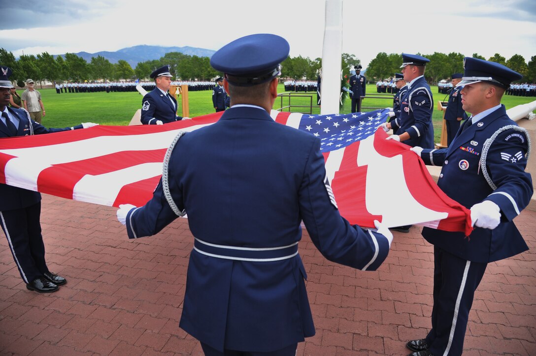 Members of the Team Kirtland Honor Guard prepare to fold the flag at a special remembrance and retreat ceremony July 15 at Hardin Field. The event honored 40 fallen Airmen who lost their lives while assigned to the wing since Sept. 11, 2001. (Photo by Ken Moore) 