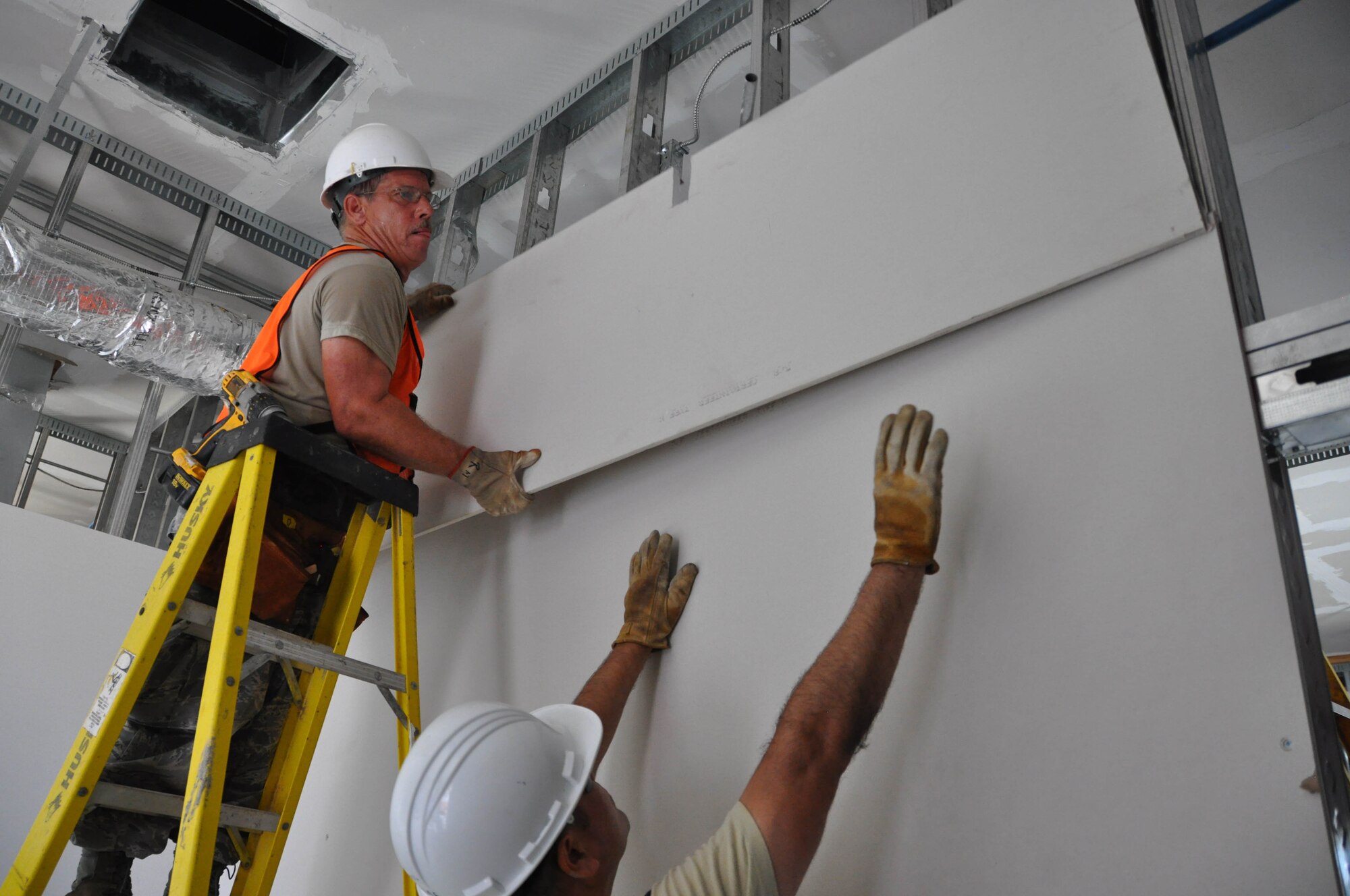 MSgt Rikey Meranda and TSgt Eduardo Ramos, 583rd RED HORSE, install sheetrock while deployed to Fletcher Field Miss. MSgt Meranda served as the safety NCO during the deployment and successfully managed to prevent any mishaps during the two week project. (U.S. Air Force Photo by Capt Joe Simms)