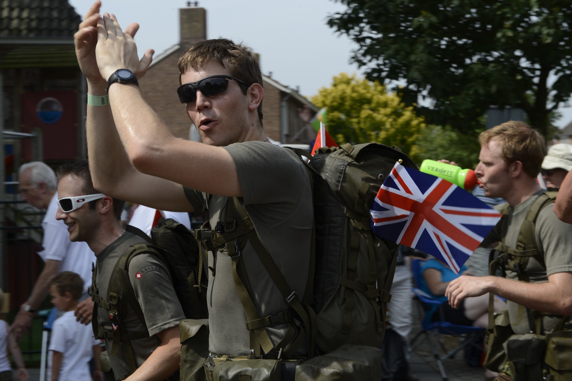 NIJMEGEN, Netherlands -- A British service member Army cheers on his comrades as he marches past spectators during the International Four Days Marches July 16, 2013 in Nijmegen, the Netherlands. Service members from various countries and branches participated in the march. (U.S. Air Force photo by Senior Airman Natasha Stannard/Released)