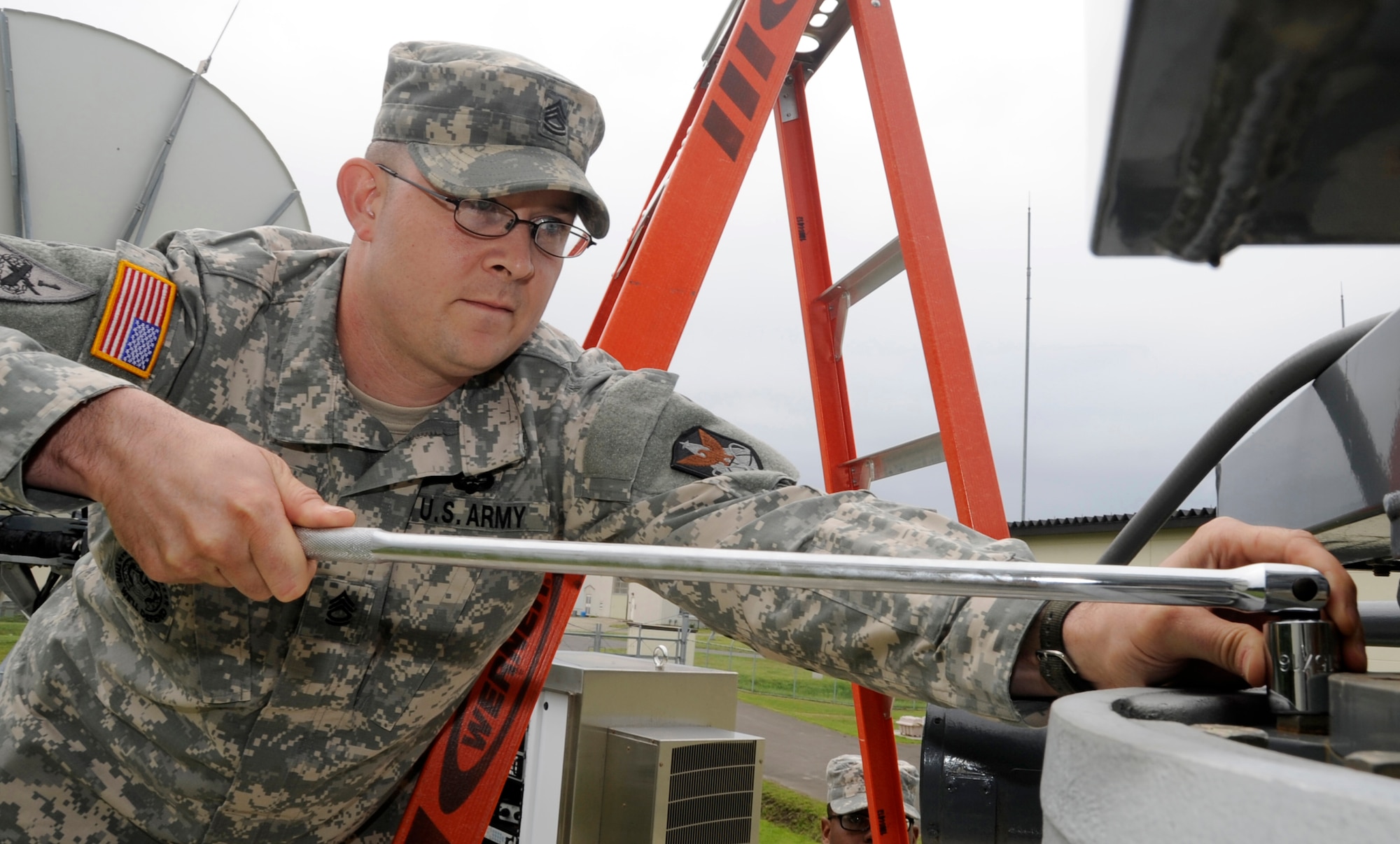 U.S. Army Sgt. 1st Class Jeffrey Johnson, Delta Detachment 1st Base Company Joint Tactical Ground Station detachment sergeant, torques the bolts on a commercial antenna at Misawa Air Base, Japan, July 17, 2013. Early warning system operators are located around the world including the United States, Japan, Korea, Germany and other loacations. Currently there are less than 100 early warning system operators in the Army. (U.S. Air Force photo by Airman 1st Class Kaleb Snay)
