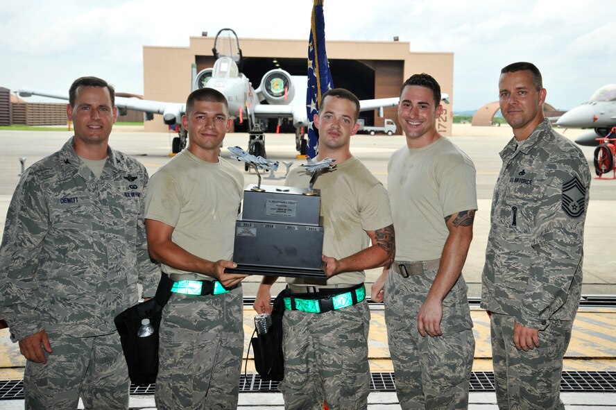 Col. Sean DeWitt, 51st Fighter Wing vice commander, presents the Load Crew of the Quarter trophy to the 25th Aircraft Maintenance Unit weapons load crew team at Osan Air Base, Republic of Korea, July 19, 2013. The 25th AMU weapons load crew team won the competition, securing the coveted trophy for the second quarter. (U.S. Air Force photo/Staff Sgt. Emerson Nuñez)