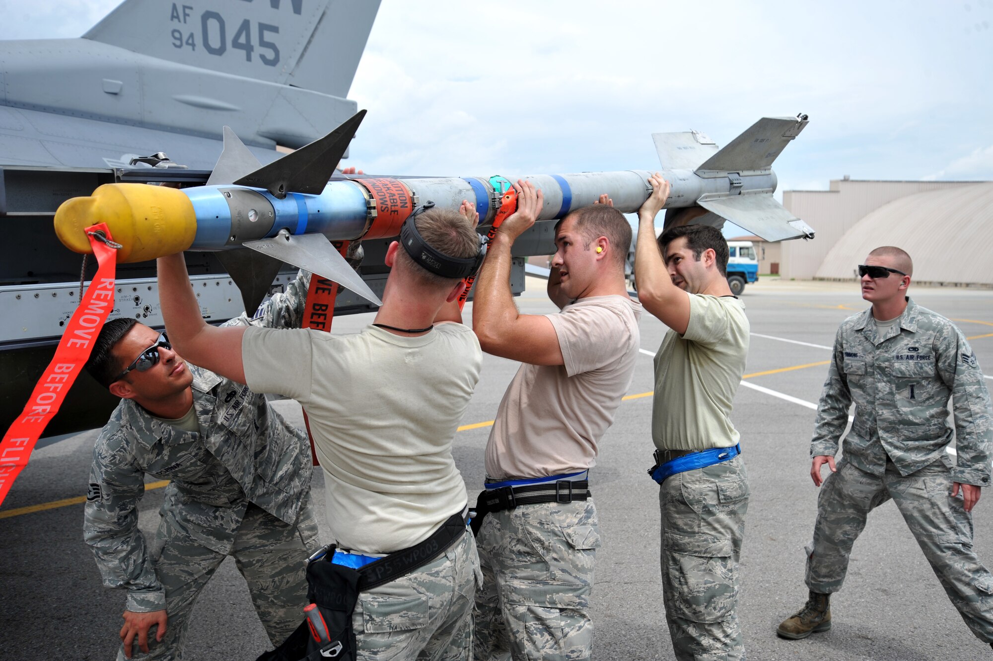 Weapons loaders from the 55th Aircraft Maintenance Unit prepare to place an AIM-9 Sidewinder missile onto an F-16 Fighting Falcon during a quarterly weapons load crew competition at Osan Air Base, Republic of Korea, July 19, 2013. Load crew competitions are held to give weapons personnel the opportunity to display their war-fighting skills and unveils the best weapons load crew for a particular quarter during the year. (U.S. Air Force photo/Staff Sgt. Emerson Nuñez)