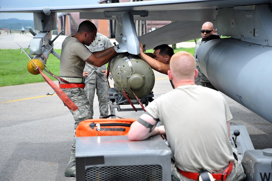 Weapons loaders from the 36th Aircraft Maintenance Unit place a CBU-103 bomb on an F-16 Fighting Falcon during a quarterly weapons load crew competition at Osan Air Base, Republic of Korea, July 19, 2013. In order for the load crews to earn their place in the competition, they must prove themselves during their monthly proficiency loads, quarterly evaluations and every-day mission. (U.S. Air Force photo/Staff Sgt. Emerson Nuñez)