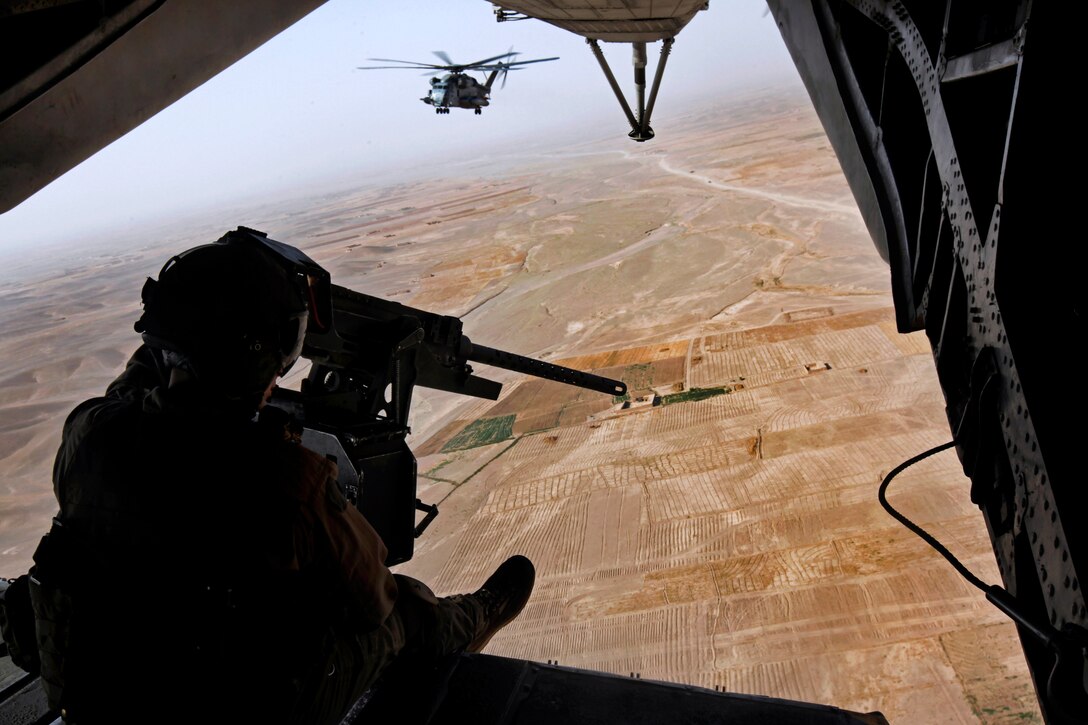 U.S. Marine Sgt. Eric R. Wagner provides aerial security from the back of a CH-53E Super Stallion helicopter after an operation over Helmand province, Afghanistan, July 18, 2013. Wagner, a crew chief, is assigned to Marine Heavy Helicopter Squadron 461.