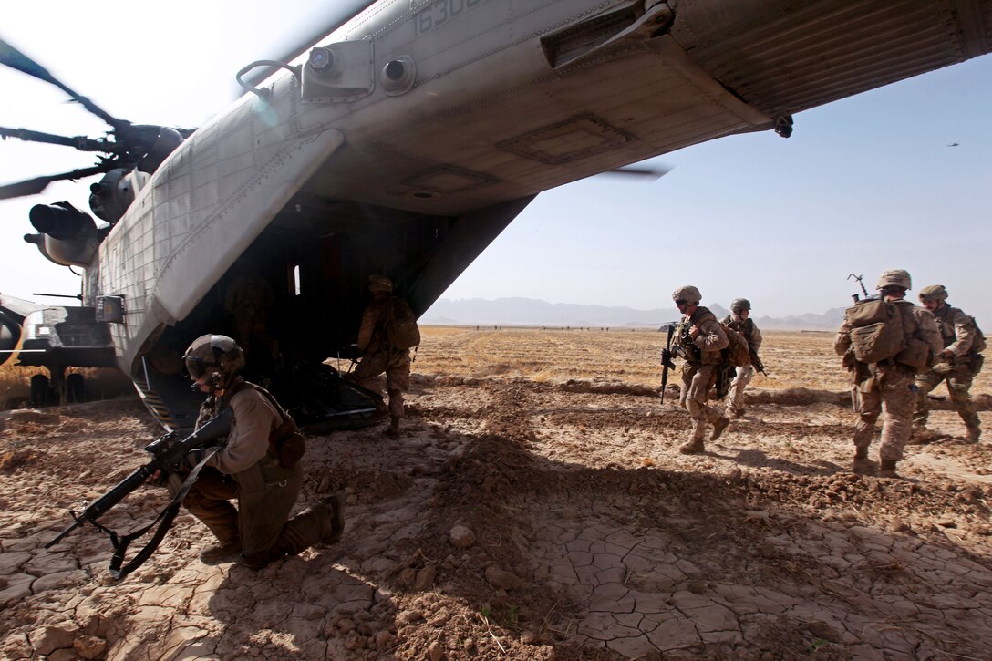 U.S. Marine Sgt. Eric R. Wagner, left, provides aerial security while U.S. Marines load up into a CH-53E Super Stallion helicopter after an operation in Tangi Sufla in Helmand province, Afghanistan, July 18, 2013. Wagner, a crew chief, is assigned to Marine Heavy Helicopter Squadron 461.