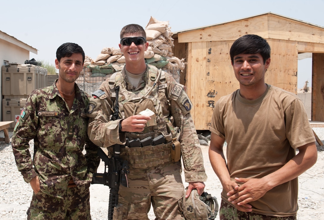 A U.S. soldier poses with two Afghan National Army soldiers for a photograph on former FOB Connolly while meeting with Afghan National Army personnel, July 7, 2013.