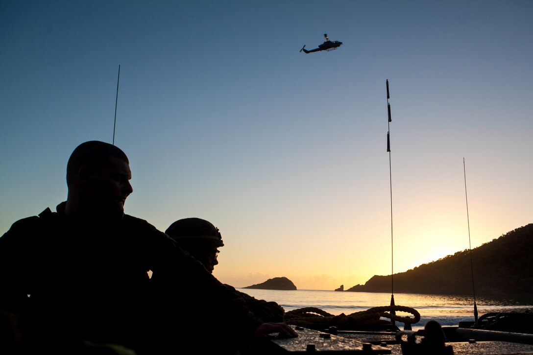 An AH-1W Super Cobra helicopter from Marine Medium Tiltrotor Squadron 265 (Reinforced) circles overhead as Marines and Sailors with Company G., Battalion Landing Team 2nd Battalion, 4th Marines, 31st Marine Expeditionary Unit, land in Amphibious Assault Vehicles during the initial stages of exercise Talisman Saber 2013 here, July 20. Company G. served as the MEU’s initial ground forces by securing a beach landing site and a nearby airfield. Talisman Saber 2013 is a biennial training exercise between approximately 18,000 joint U.S. forces and approximately 9,000 Australian forces, aimed at improving combat readiness and interoperability. The 31st MEU is the Marine Corps’ force in readiness for the Asia Pacific region and the only continuously forward-deployed MEU. 