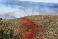 Airmen from the Air Force Reserve Command's 302 Airlift Wing based at Peterson AFB, Colo., follow the lead plane to see where to drop their next load of fire retardant. The fire retardant is colored red to show where drops have already been made.
