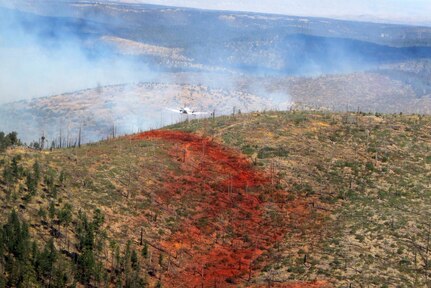 Airmen from the Air Force Reserve Command's 302 Airlift Wing based at Peterson AFB, Colo., follow the lead plane to see where to drop their next load of fire retardant. The fire retardant is colored red to show where drops have already been made.
