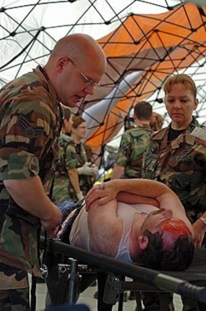 Air National Guard medical technicians from the Illinois National Guard's Chemical, Biological, Radiological and Nuclear Enhanced Response Force Package (CERFP) evaluate a role-playing victim of a collapsed building for injuries in mid-May as part of the National Guard training exercise Vigilant Guard in Indiana.