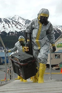 Members of the National Guard's civil support team board the USNS Henry J. Kaiser in biohazard suits here May 11 to investigate a simulated report of suspicious chemicals aboard during an exercise scenario for Alaska Shield/Northern Edge 2007. The civil support team worked in conjunction with the Seward police and fire departments, the Coast Guard, the FBI, and many other organizations to practice interagency coordination in an emergency situation. AKS/NE 07 is a State of Alaska/US NORTHCOM sponsored homeland defense and defense support of civil authorities exercise; part of the national-level Ardent Sentry/Northern Edge 07.
