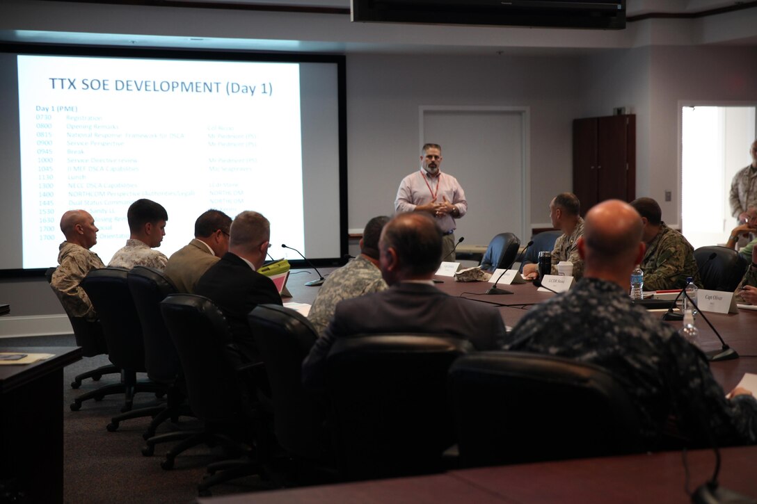 : Military and civilian Defense Support of Civil Authorities, or DSCA, planners discuss the schedule and topics for the two-day DSCA meeting held aboard Camp Lejeune, N.C., July 18, 2013. After a day of speaking about the responsibilities of each unit and organizations for humanitarian operations, the group played through the events of a hypothetical hurricane, which damaged Alabama and surrounding states, as a means to increase efficiency in an actual event.