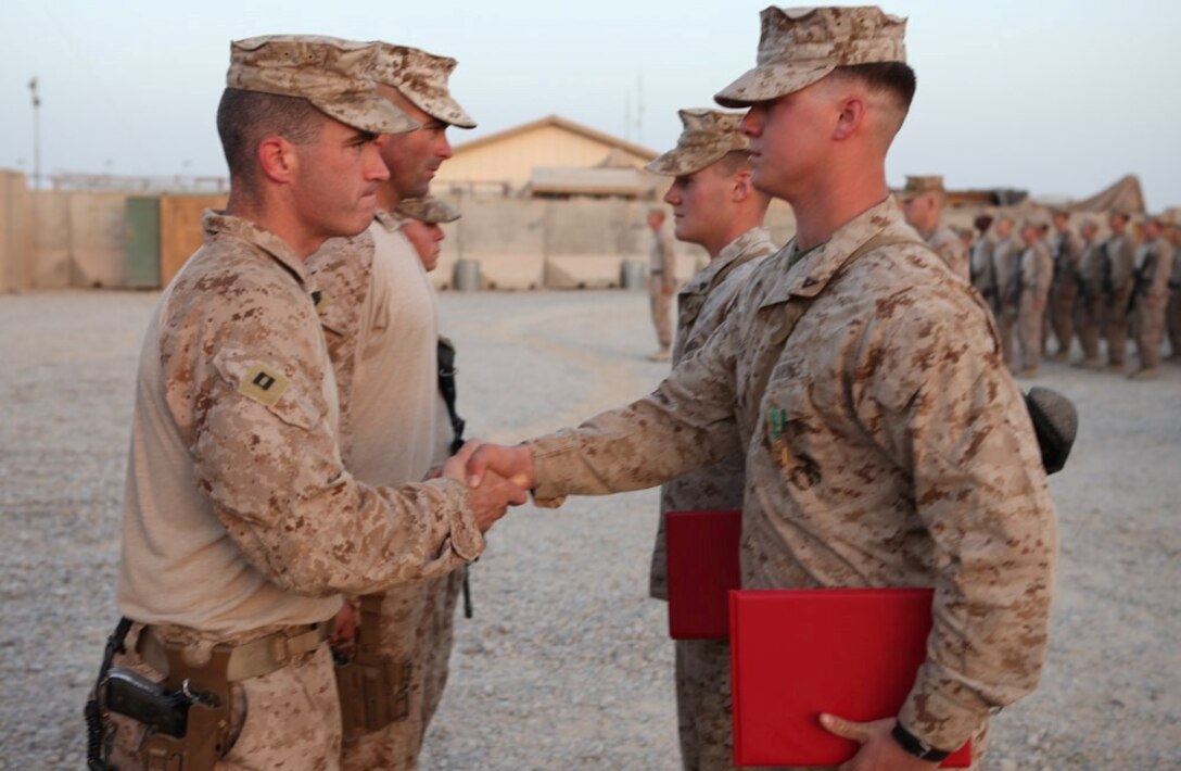 Lance Cpl. Timothy Pierce, 24, from Wallace, N.C., shakes hands with Capt. Todd Richardson, the Echo Company company commander with 2nd Battalion, 8th Marine Regiment, Regimental Combat Team 7, after being awarded the Navy and Marine Corps Achievement Medal for his decisive thinking and quick response to a car accident. "It wasn't a duty," explained Pierce. "It was just decent human nature and the right thing to do."