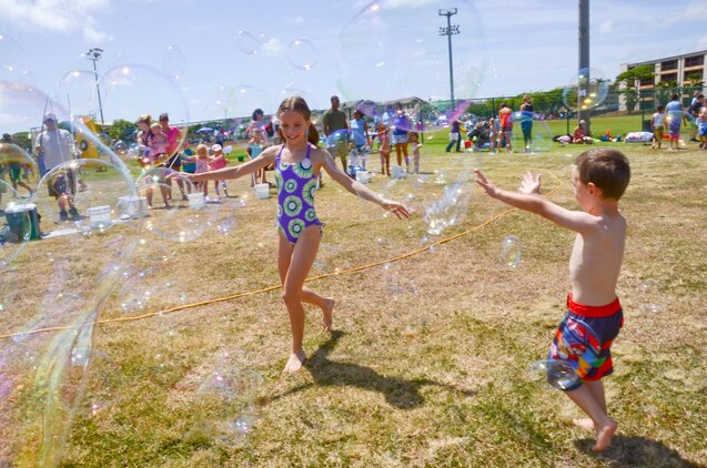 Madison Frazier, 11 (left) and her brother Henry, 4, run through a sea of bubbles during the Summer Splashdown at Riseley Field, July 13, 2013. Marine Corps Base Hawaii families engaged in numerous water activities at the event. (U.S. Marine Corps photo by Kristen Wong)