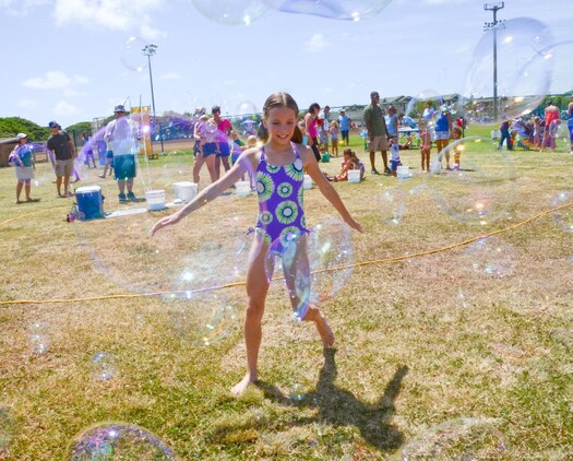 Madison Frazier, 11, runs through a sea of bubbles during the Summer Splashdown at Riseley Field, July 13, 2013. Marine Corps Base Hawaii families engaged in numerous water activities at the event. (U.S. Marine Corps photo by Kristen Wong)