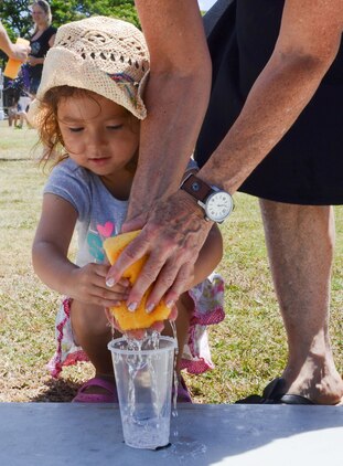 Victoria Alexander, 4, and her grandmother compete in a relay race during the Summer Splashdown at Riseley Field, July 13, 2013. Participants filled a sponge and raced each other to fill a cup with water. (U.S. Marine Corps photo by Kristen Wong)