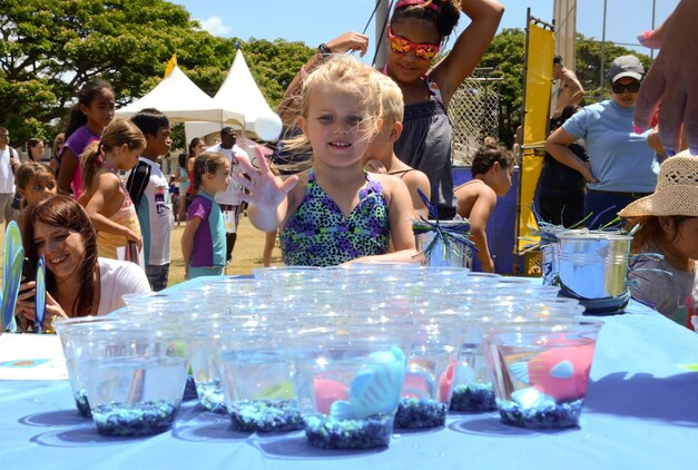 Lily Sykes, 5, tries to toss a ball into a cup during the Summer Splashdown at Riseley Field, July 13, 2013. (U.S. Marine Corps photo by Kristen Wong)