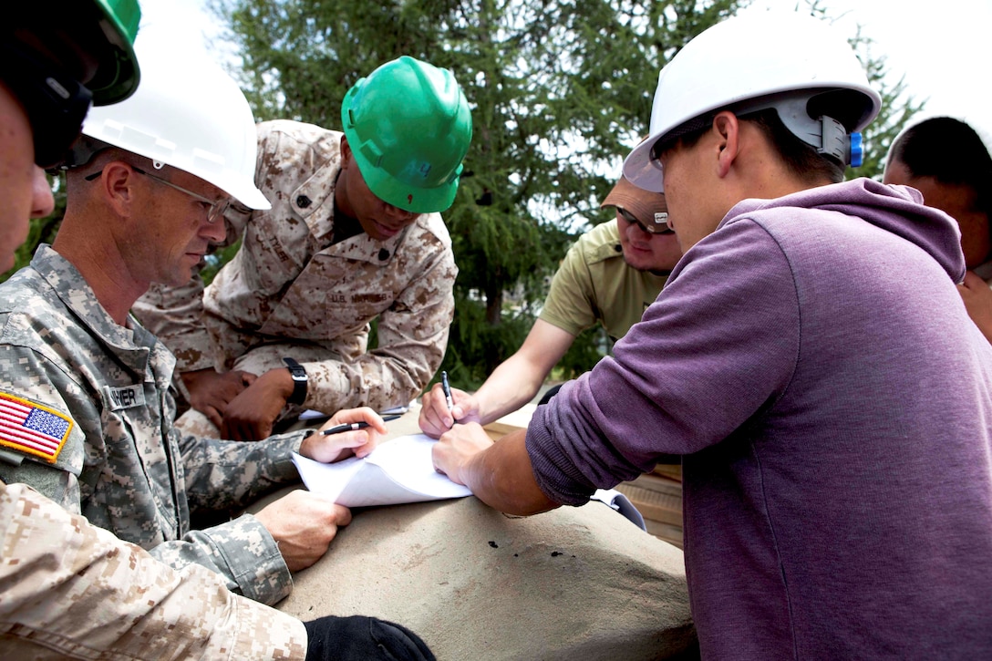 U.S. and Mongolian engineers review the renovation plan from the rooftop of Erdmiin Oyun High School in the Nalaikh district of Ulaanbaatar, Mongolia, July 20. The Mongolian and U.S. armed forces are working side-by-side as part of Exercise Khaan Quest 2013, a regularly scheduled, multinational exercise co-sponsored this year by U.S. Marine Corps Forces Pacific, and hosted annually by the MAF. The intent of the ongoing engineering civic action program (ENCAP) project in Nalaikh is to provide valuable training for Mongolian and U.S. armed forces by boosting their interoperability, as well as demonstrate a mutual commitment to local community.