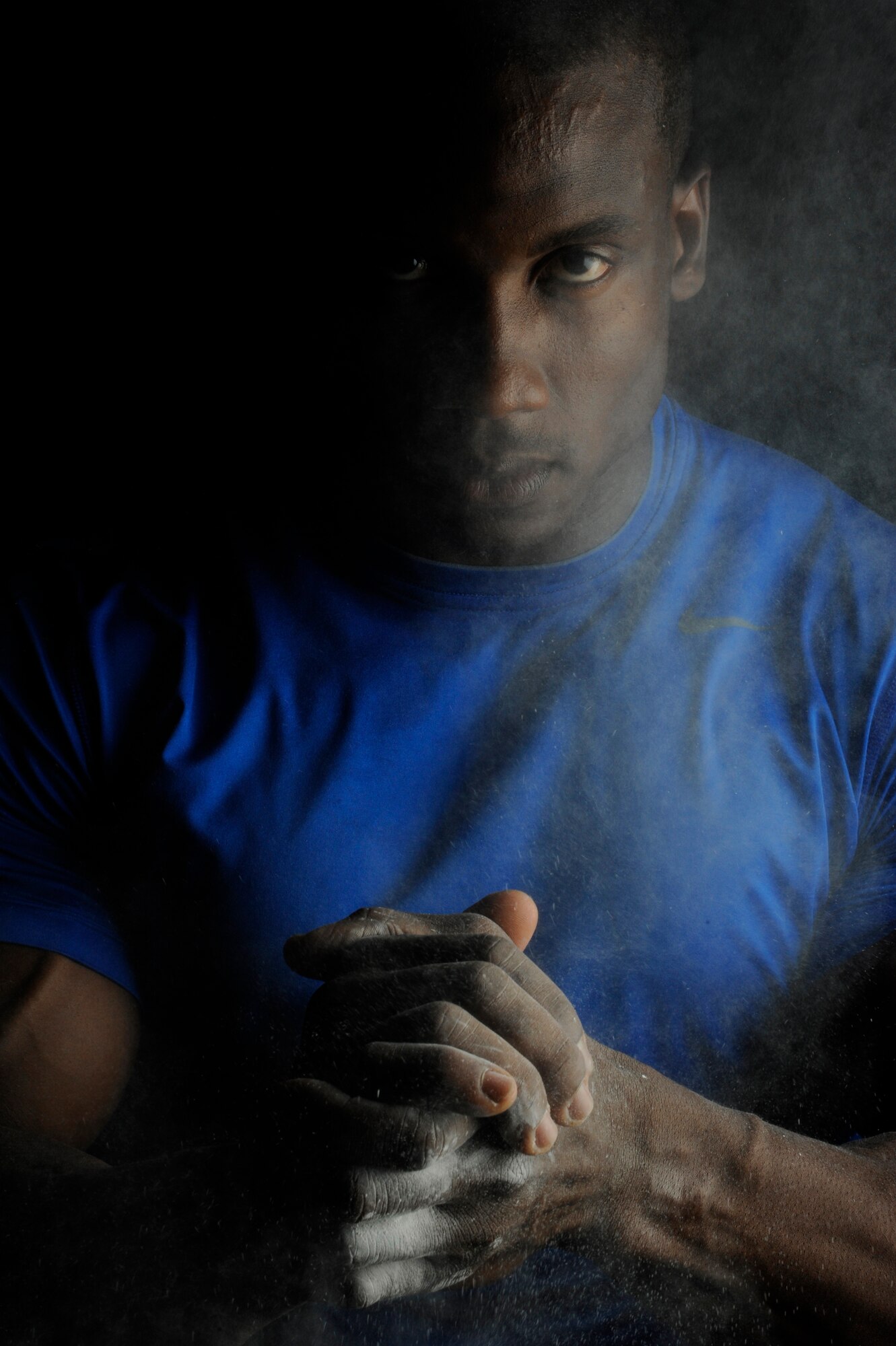 Staff Sgt. Robert Timms, 8th Aircraft Maintenance Squadron unit fitness program manager, rubs chalk on his hands to help increase his grip while lifting weights at Kunsan Air Base, Republic of Korea, July 19, 2013. Timms is certified in personal training, a passion fueled by overcoming cancer and wanting to give back. (U.S. Air Force photo by Senior Airman Jessica Haas/Released)