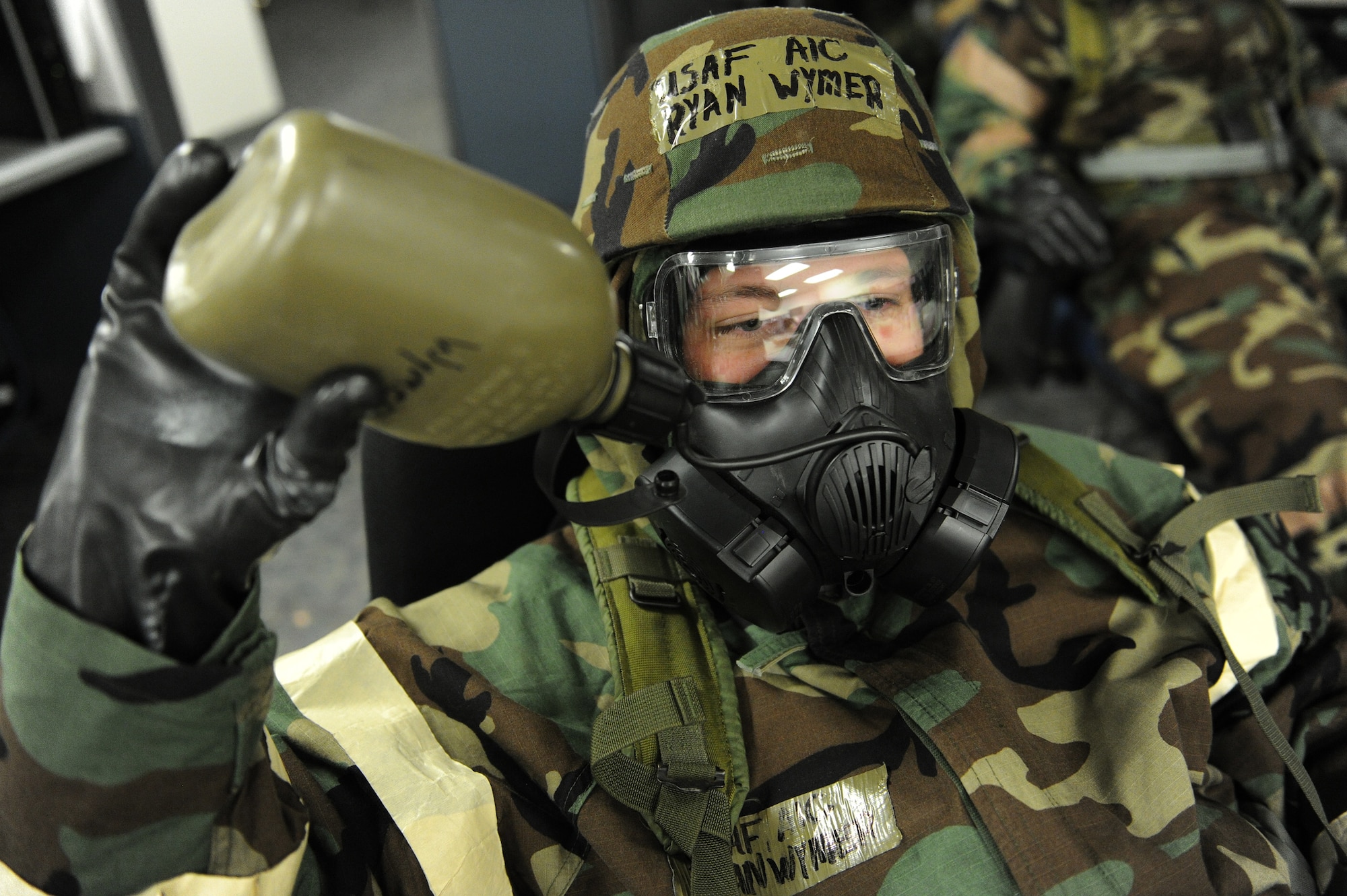 Airman 1st Class Ryan Wymer, 15th Aircraft Maintenance Squadron, takes a drink from his canteen while in mission-oriented protective posture four during an Operational Readiness Exercise at Joint Base Pearl Harbor-Hickam, Hawaii, July 18, 2013. Much like standardized attack warning signals, MOPP quickly increases or decreases Airmen’s protection against chemical, biological, radiological or nuclear threats. (U.S. Air Force photo/Tech. Sgt. Jerome S. Tayborn)  