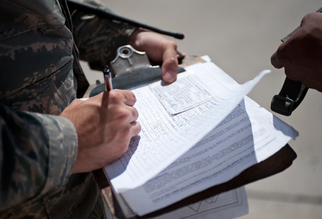 Airman 1st Class Steven Hernandez, 28th Operations Support Squadron Airfield Management operations coordinator, performs a spot check for proper documentation to ensure Airman 1st Class Jeffery Reinke, 28th Security Forces Squadron patrolman, has the correct credentials required to drive on the flightline at Ellsworth Air Force Base, S.D., July 19, 2013. Spot checks like this allow airfield management Airmen to verify personnel are qualified to drive on the flightline. (U.S. Air Force photo by Airman 1st Class Alystria Maurer/Released)