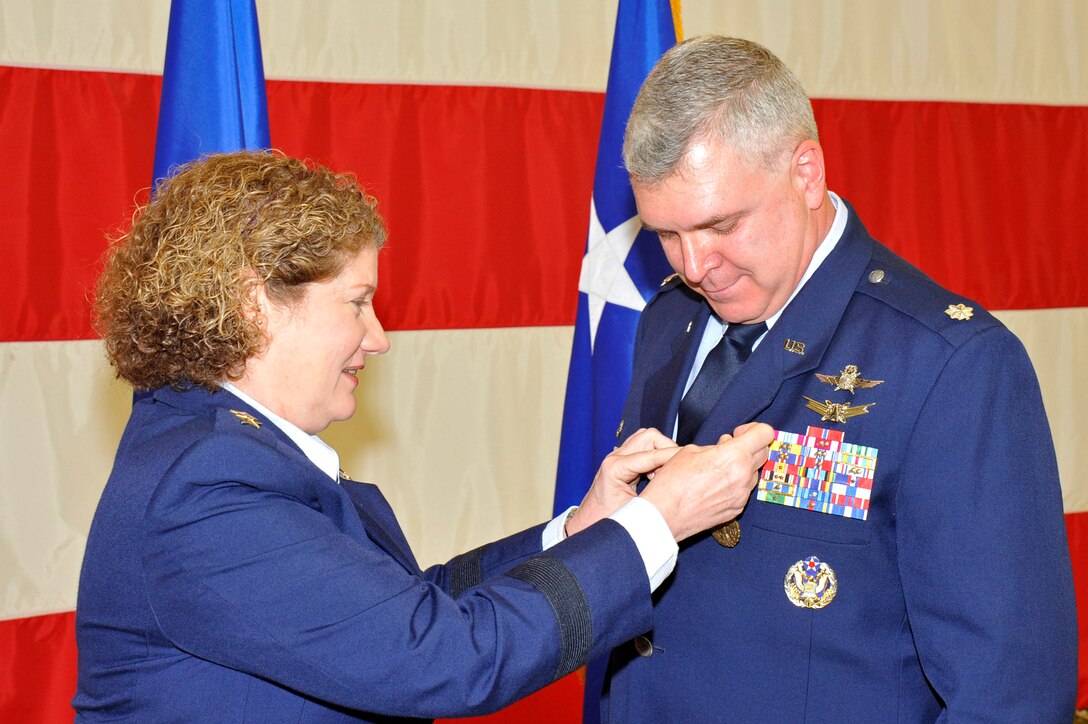 VANDENBERG AIR FORCE BASE, Calif. -- Lt. Gen. Susan Helms, commander of U.S. Strategic Command's Joint Functional Component Command for Space and 14th Air Force (Air Forces Strategic), presents Lt. Col Robert Thompson, outgoing 614th Air and Space Communications Squadron commander, with a Meritorious Service Medal during the 614th ACOMS change-of-command ceremony here July 9, 2013. Thompson commanded the squadron from June 2011 to July 2013. (U.S. Air Force photo/Michael Peterson)