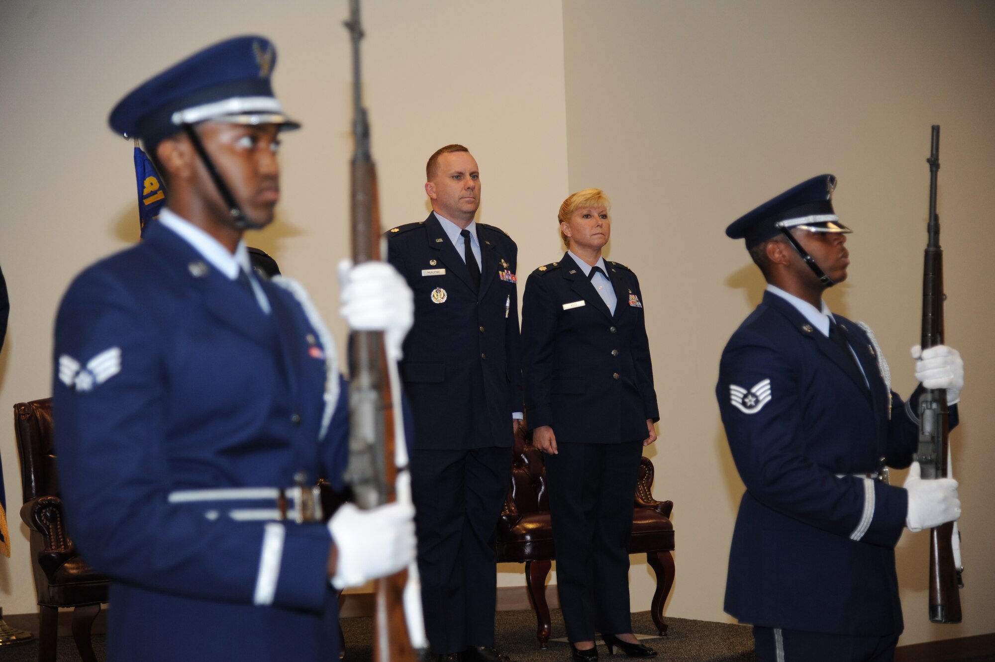 Lt. Col. Bradley McAlpine, outgoing 335th Training Squadron commander and Lt. Col. Dorene Ross, incoming 335th TRS commander, (center), stand at attention as Keesler Honor Guard members post the colors during the 335th TRS change of command ceremony July 22, 2013, at the Roberts Consolidated Aircraft Maintenance Facility, Keesler Air Force Base, Miss.  Col. George Tombe, 81st Training Group commander, was the officiating officer for the event.  (U.S. Air Force photo by Kemberly Groue)