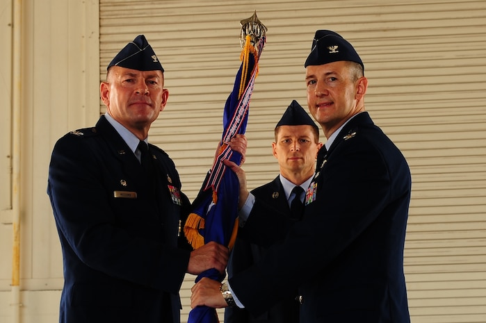 Col. Richard McComb (left), Joint Base Charleston commander, hands the guidon to Col. Michael Mongold, during the 628th Mission Support Group change of command ceremony July 18, 2013, at JB Charleston – Air Base, S.C. Mongold was commissioned in 1991 through the Air Force ROTC program at West Virginia University. He entered the Air Force as a Civil Engineer officer assigned to Altus Air Force Base, Okla. (U.S. Air Force photo/ Airman 1st Class Chacarra Neal)