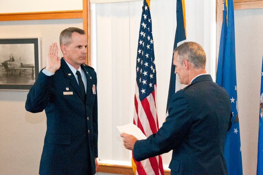 Newly promoted Lt. Col. Trenton Twedt (left), 132nd Maintenance Squadron Commander, 132nd Fighter Wing (132FW), Des Moines, Iowa, raises his right arm and recites the Oath of Office, deliverd by Col. Randy Greenwood (right), 132nd Maintenance Group Commander, 132FW, on July 3, 2013.  (U.S. Air National Guard photo by Senior Airman Dustin M. Smart/Released)