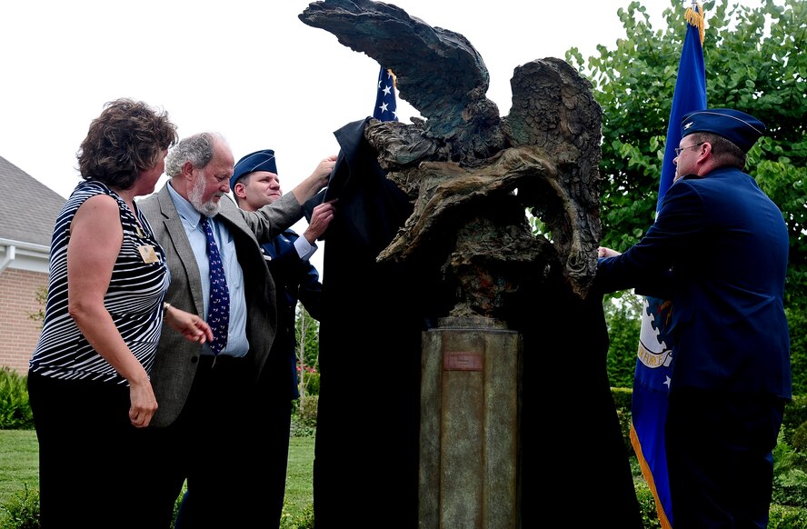 From left, Karen Mordus, President of Friends of the Fallen, Greg Wyatt, sculptor, Col. John Devillier, Air Force Mortuary Affairs Operations commander, and Col. Rick Moore, 436th Airlift Wing commander, unveil a bronze sculpture, named The Angel of the Dying Unknown at Dover Air Force Base, Del., July 22, 2013. The sculpture is located in the memorial garden near the Center for Families of the Fallen and will serve as a quiet reflection on the sacrifices made by the nation’s fallen service members. (U.S. Air Force photo by Senior Airman Melanie Bulow-Kelly/Released)