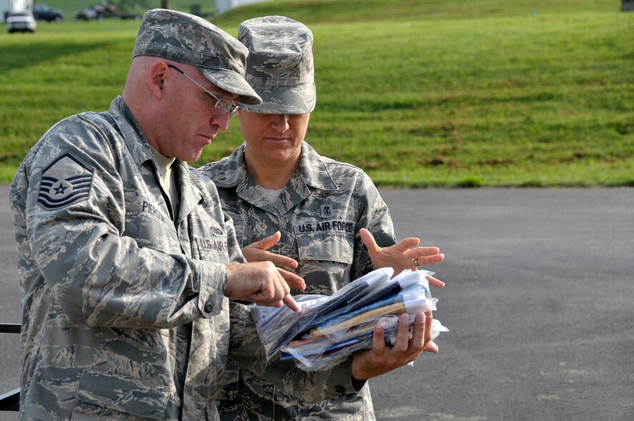 MCGHEE TYSON AIR NATIONAL GUARD BASE, Tenn. – Master Sgt. Don Pierson hands out state flags to Master Sgt. Veronica Ross on the morning of July 18, 2013. Every six months, Airmen from the I.G. Brown Training and Education Center meet on the parade ground here to take down and replace the flags of the nation’s states and territories. (U.S. Air National Guard photo by Master Sgt. Mike R. Smith/Released)
