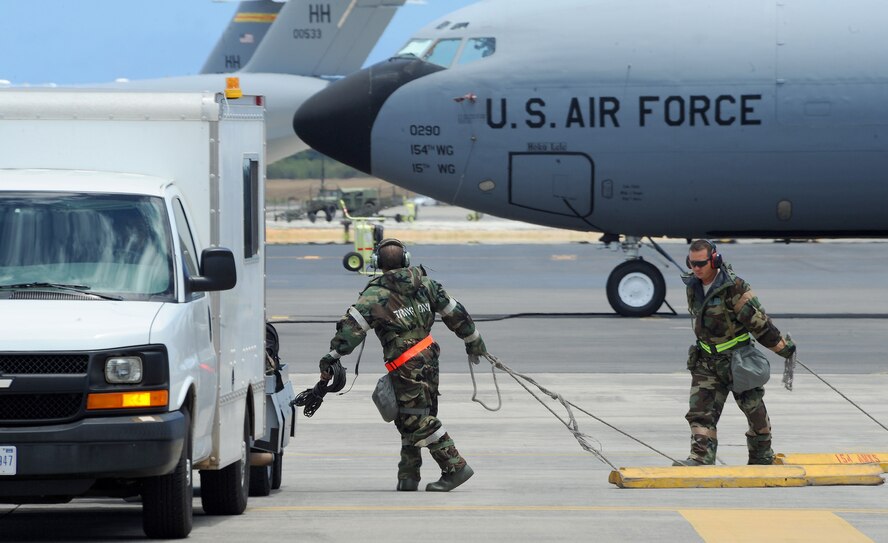 Members of the 15th Wing and the Hawaii Air National Guard 154th Wing pull chalks after launching a KC-135 Stratotanker on the flightline during an Operational Readiness Exercise at Joint Base Pearl Harbor-Hickam, Hawaii, July 18, 2013.  The refueling capabilities of the KC-135 aircraft are essential in today’s Air Force, and have been refueling the fleet for more than 50 years. (U.S. Air Force photo/Tech. Sgt. Jerome S. Tayborn)  