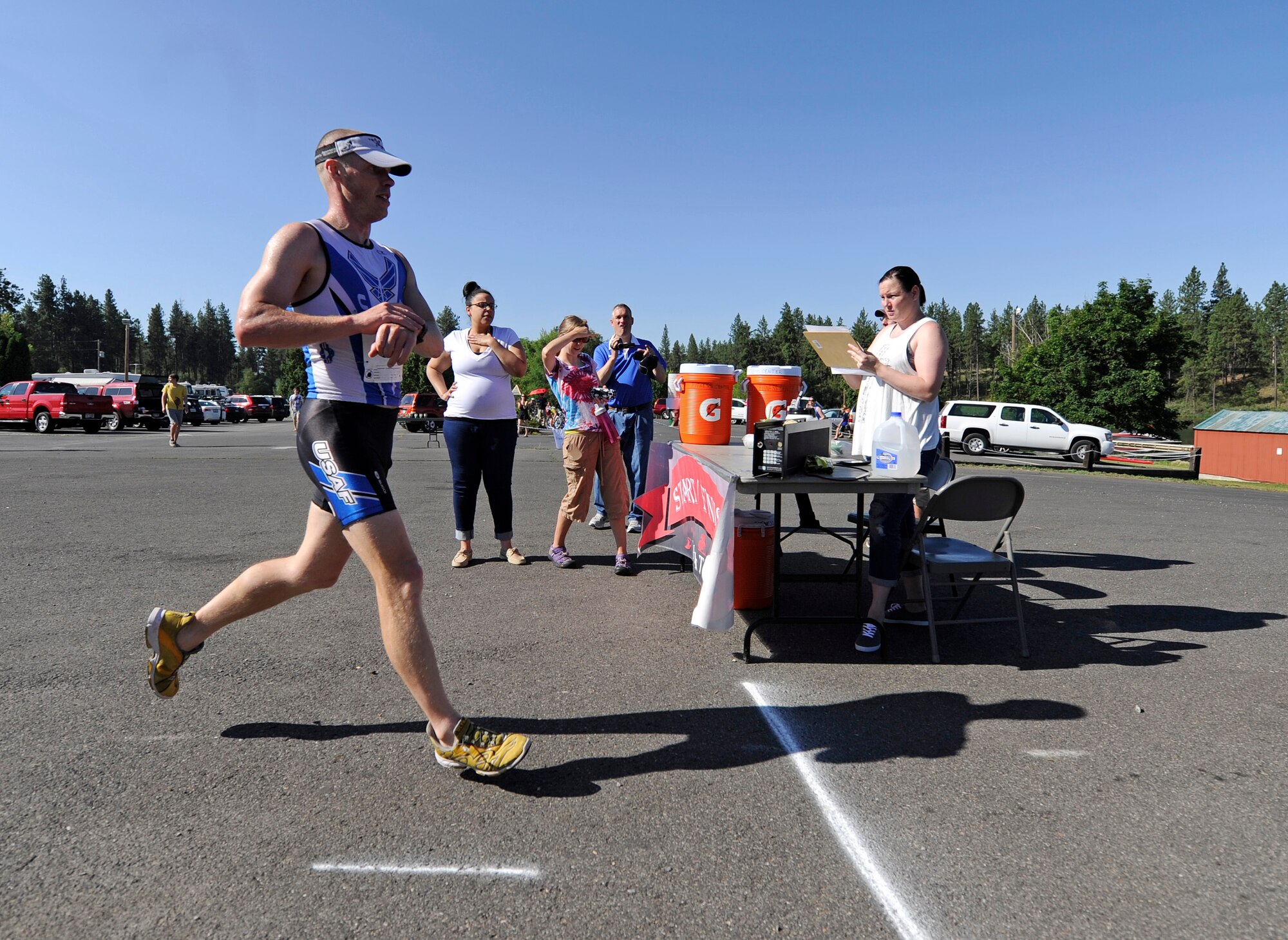 Tech. Sgt. Michael Bergquist, Air National Guard, is moments away from crossing the finish line in the Clear Lake triathlon near Medical Lake, Wash., July 20, 2013. Bergquist finished 1st place out of all the participants. (U.S. Air Force photo by Airman 1st Class Ryan Zeski/Released)