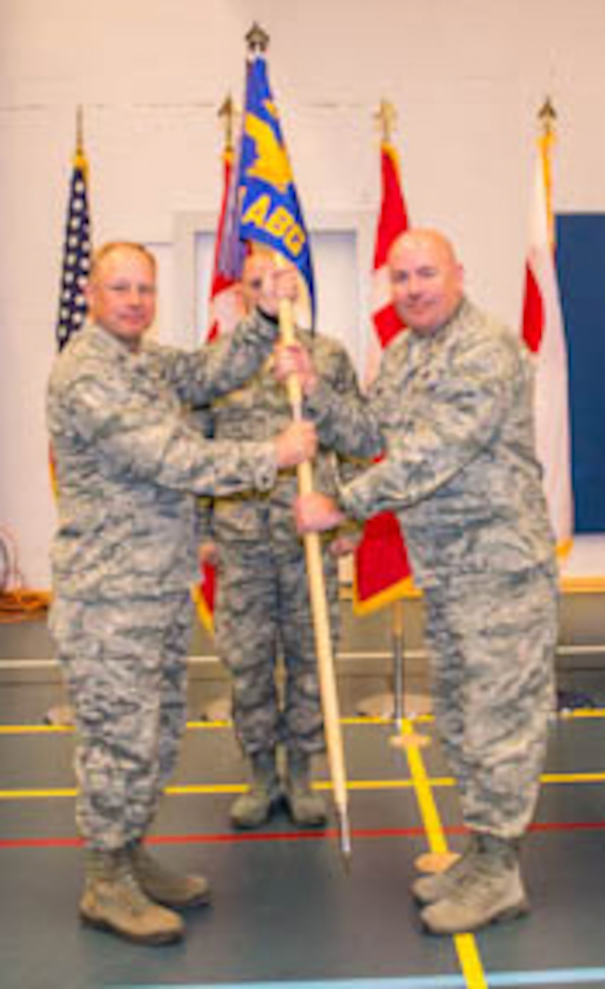 THULE AIR BASE, Greenland – Col. Chris Crawford (left), 21st Space Wing commander, passes the 821st Air Base Group guidon to Col. Joseph Prue, during a change of command ceremony at Thule AB. Prue took command of the 821st ABG July 18. The 821st ABG is one of the six installations operated by the 21st Space Wing, and supports Thule’s missile warning, missile defense, space surveillance, and satellite command and control missions through comprehensive base support and integrated defense of the 254 square mile Thule Defense Area. Prue replaced outgoing commander Col. Mike Colón. (U.S. Air Force photo)