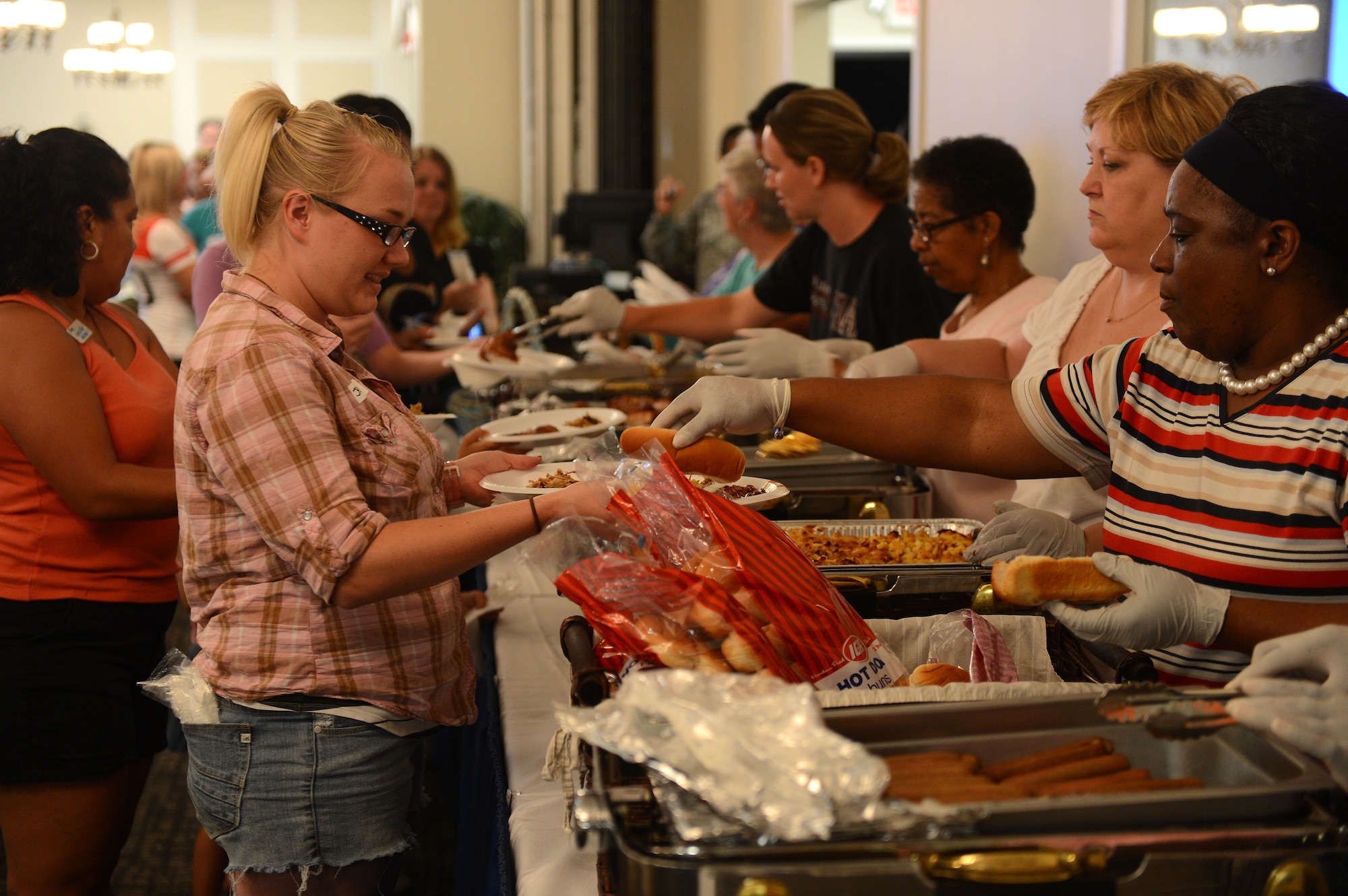 Volunteers provide free food during a deployed spouses dinner at Shaw Air Force Base, S.C., July 22, 2013. Deployed spouses dinners are held regularly to provide support and encouragement to families of deployed service members. (U.S. Air Force photo by Airman 1st Class Daniel Blackwell/Released)