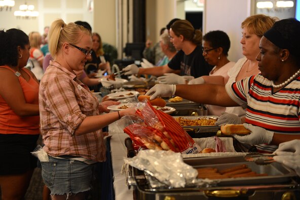 Volunteers provide free food during a deployed spouses dinner at Shaw Air Force Base, S.C., July 22, 2013. Deployed spouses dinners are held regularly to provide support and encouragement to families of deployed service members. (U.S. Air Force photo by Airman 1st Class Daniel Blackwell/Released)