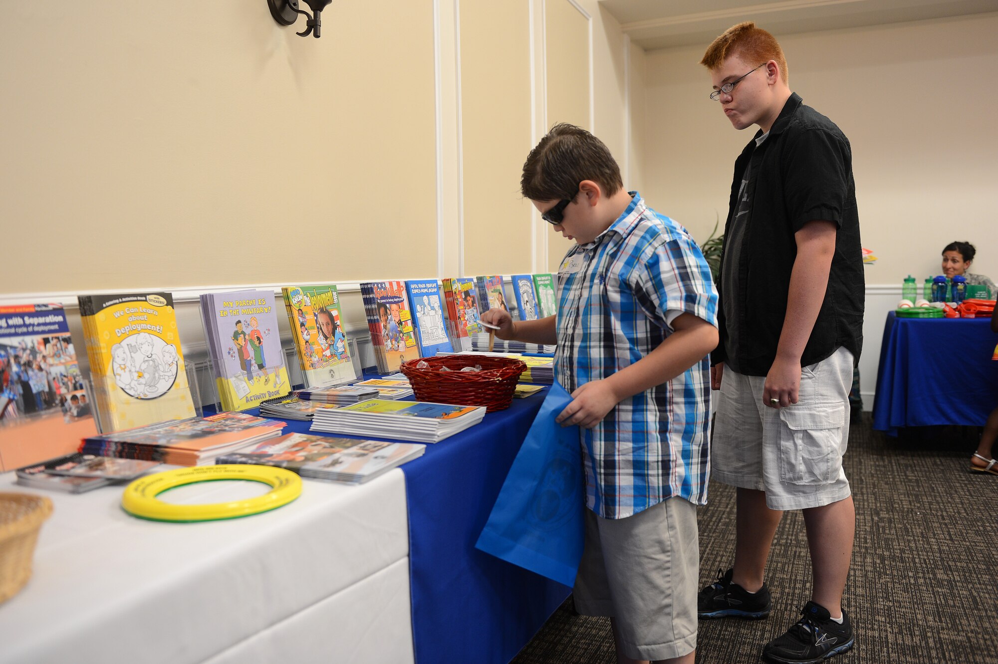 Children of deployed service members browse a table of pamphlets and gifts during the deployed spouse dinner at Shaw Air Force Base, S.C., July 22, 2013. Deployed-spouses dinners are held regularly to provide support and encouragement to families of deployed service members. (U.S. Air Force photo by Airman 1st Class Daniel Blackwell/Released)