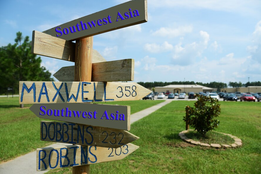 A mileage stake to Afghanistan from Shaw Air Force Base stands outside the 28th OWS. Airmen from the 28th OWS forecast for the Middle East and U.S. Air Forces Central Command’s Area of Responsibility (U.S. Air Force photo manipulation by Airman 1st Class Jonathan Bass/Released)